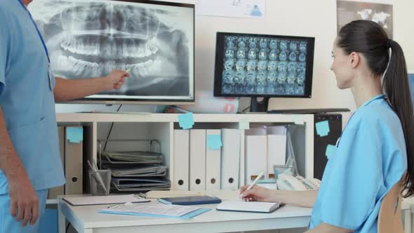 Pair of Professional Stomatologists Analyzing X-ray Image