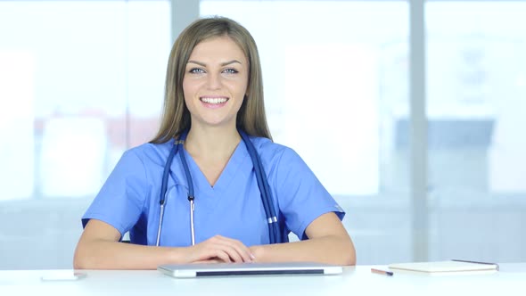 Portrait of Smiling Positive Female Doctor Sitting in Clinic