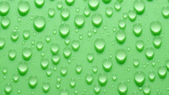 Closeup Transparent Water Drops Texture Rotating on Green Chroma Key Background