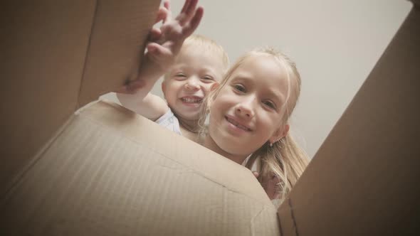 Two Children Looking Into a Box. Happy Children Opening Gifts