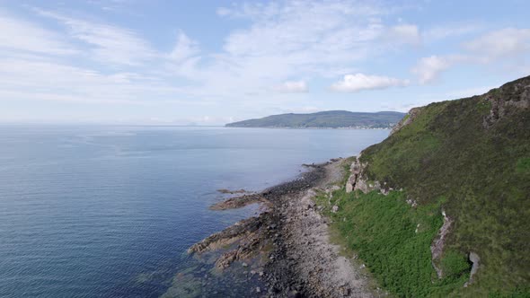 Flying Along the Coast of the Holy Isle in Scotland with Beautiful Mountains