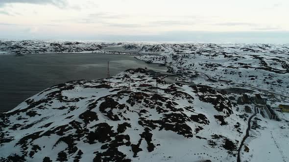 The Drone Flies Up to the Communication Towers in a Small Northern Town on the Coast Surrounded By