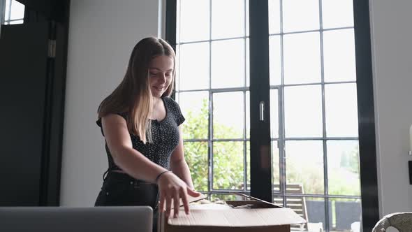 Teenage girl opening parcel with new clothes