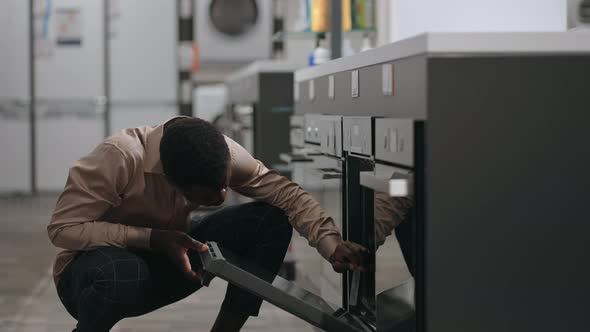 Afroamerican Man is Shopping in Home Appliances Store Black Guy is Choosing Equipment for Home