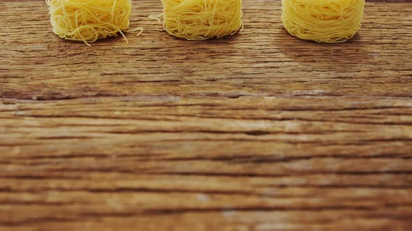 Three roll of spaghetti on wooden table