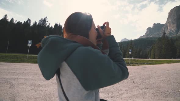 Happy Young Woman Photographer Walks in the Dolomites Mountains