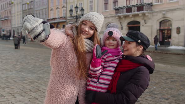 Lesbian Couple Tourists with Adoption Child Girl Taking Selfie or Making Video Chat on City Street