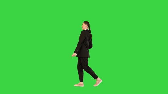 Young Woman in Office Suit Walking Like a Model Raising Hands on a Green Screen Chroma Key