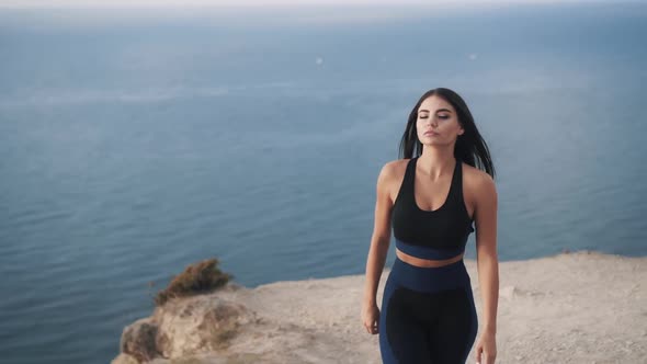 Beautiful Slim Sexy Caucasian Woman Moves Away From the Edge of the Cliff