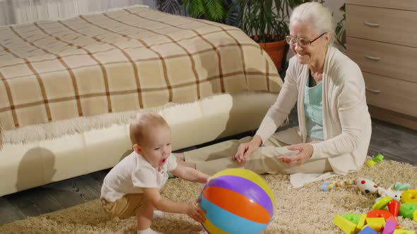 Senior Grandmother Playing with Little Grandson at Home