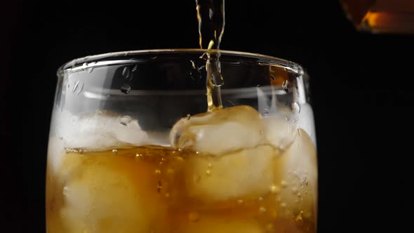 Whisky is poured into glass in slow motion