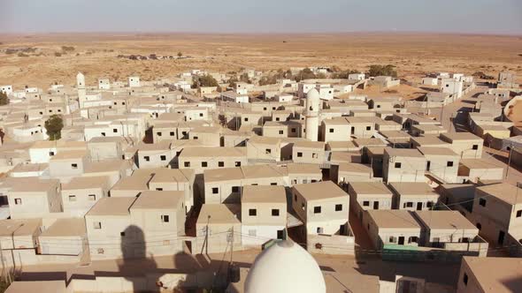 aerial shot revealing two mosques at palestine near gaza in the desert at an empty city.