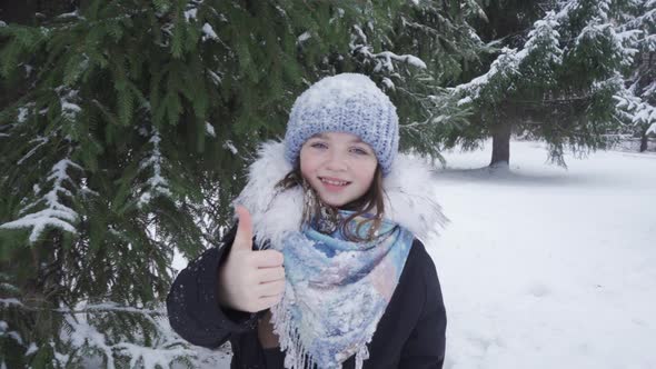 Portrait of a Happy Blueeyed Teenage Girl in a Snowy Park