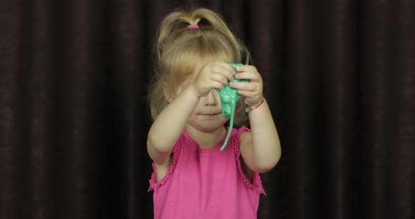 Child Having Fun Making Green Slime. Kid Playing with Hand Made Toy Slime