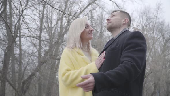 Beautiful Blond Caucasian Woman and Brunette Man Dating in Park in Cloudy Day