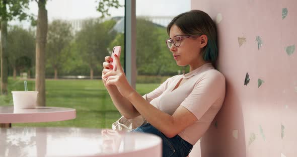 a Millennial Woman Takes a Selfie in a Cozy Cafe for Her Blog or Social Network