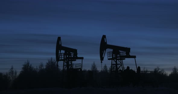 Two Silhouettes of Oil Rigs Close Up