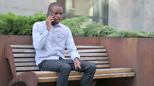 Upset African Man Angry on Smartphone Outdoor