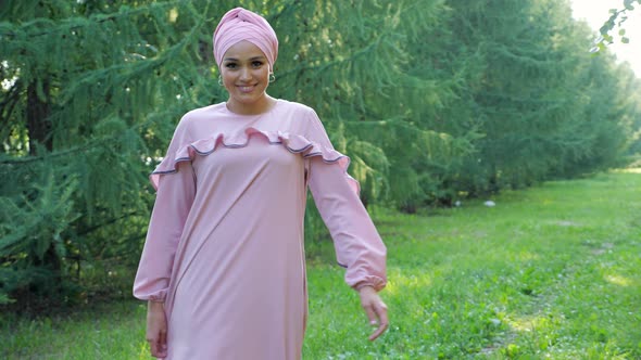 Professional Model in Purple Dress and Hijab Poses on Grass