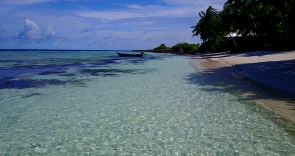 Wide above copy space shot of a sandy white paradise beach and blue water background in 4K