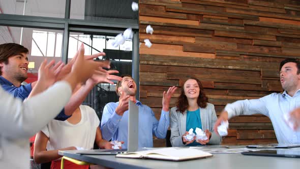 Business executives throwing crumpled paper in air