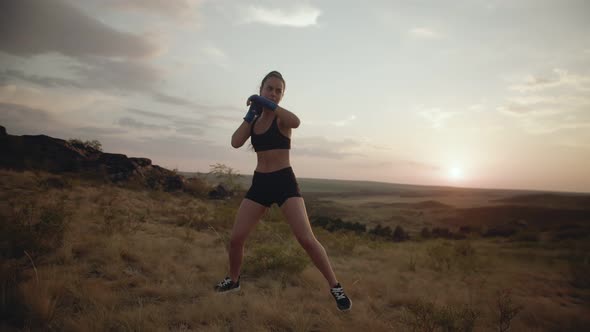 Serious strong aggressive woman fights in the field as a symbol of successful woman.