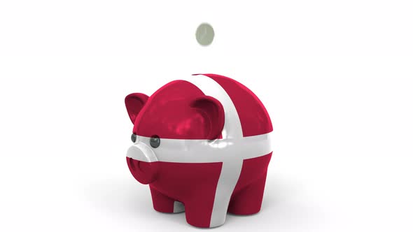Coins Fall Into Piggy Bank Painted with Flag of Denmark alt