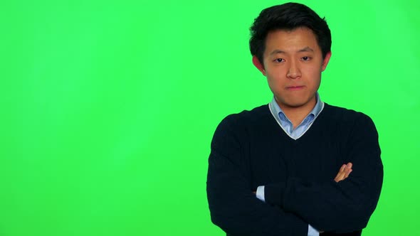 A Young Asian Man Shakes His Head Disapprovingly, His Arms Folded Across His Chest - Green Screen