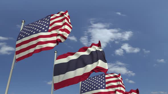 Flags of Thailand and the USA Against Blue Sky
