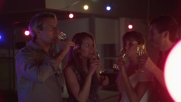 Friends drinking champagne together at night