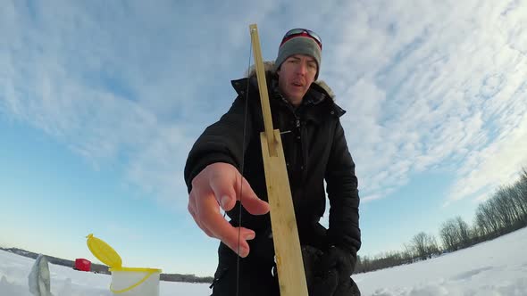 Ice fisherman setting up the bait for fishing