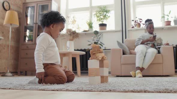 Sweet Little Boy Playing with Toys in Living Room