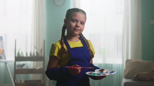 Portrait of Small Girl In Blue Apron