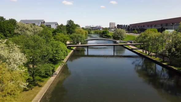 The Drone Flies Over the River in the Park