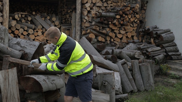 Lumberjack in Reflective Jacket. Man Woodcutter Hold Huge Axe Show Ok Sign. Sawn Logs, Firewood