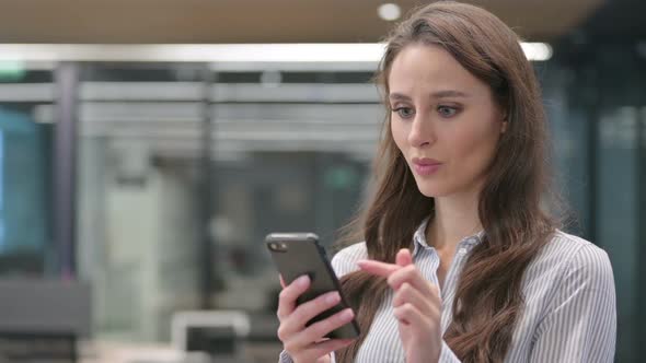 Portrait of Young Businesswoman Celebrating on Smartphone