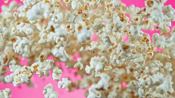 Super Slow Motion Shot of Popcorn on Pink Background After Being Exploded at 1000Fps