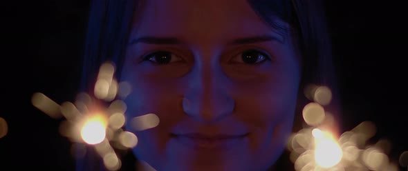 Close up of a woman smiling with two sparkles in front of her