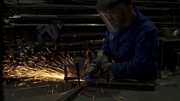 Anonymous workman welding metal construction in workshop