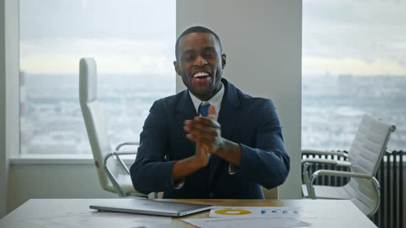 Young business man in a suit clapping at the camera