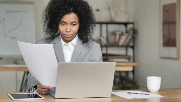 African Businesswoman Reading Documents at Work