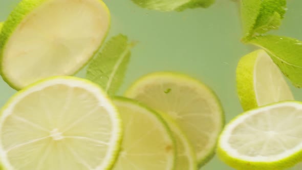 Lemon and Lime Cocktail Cooking Cold Lemonade Citrus Fruits in Water on Green Background Shooting of