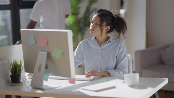 Professional African American Millennial Woman Listening to Video Chat on Screen and Surfing