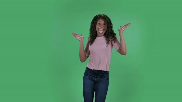 Portrait of Beautiful African American Young Woman Looking at Camera and Performs a Dance of Joy and