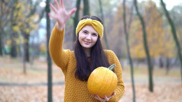 Woman Holding Pumpkins in Hands on an Autumn Sunny Day in the Forest