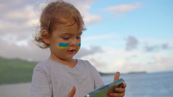 The Child Watches the News on the Phone