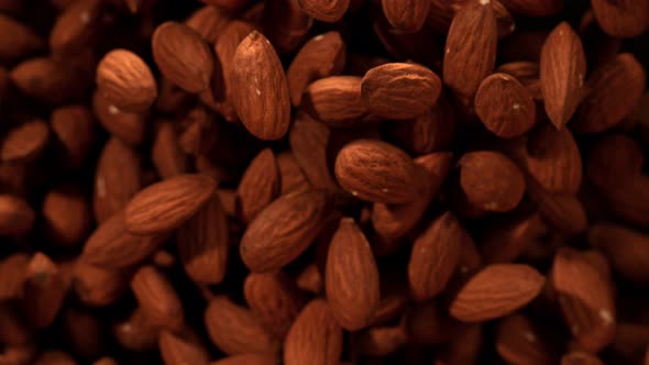 Super Slow Motion Shot of Almonds Flies After Being Exploded Against Black Background, 1000Fps