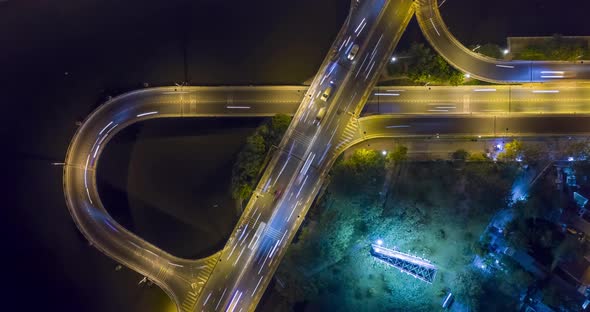 Top down night hyperlapse of freeway ramps and loops with heavy traffic with light streaks. Camera s