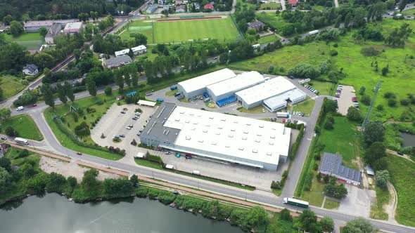 Buildings of logistics center, warehouses near the highway, truck parking process, view from height,