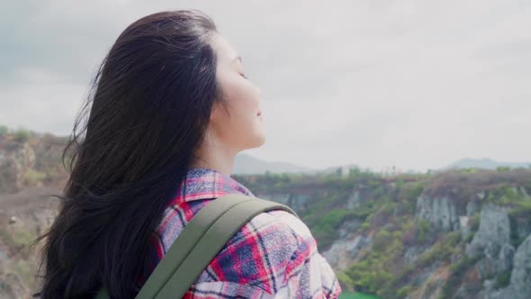 Asian backpacker woman on top of mountain holidays on hiking adventure feeling freedom.